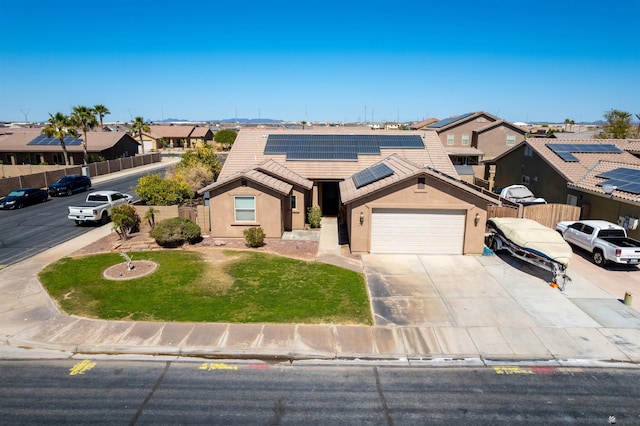 7942 E 36th Ln, Yuma, AZ 85365 - view of front of home featuring a garage, roof mounted solar panels, concrete driveway, stucco siding, and a residential view