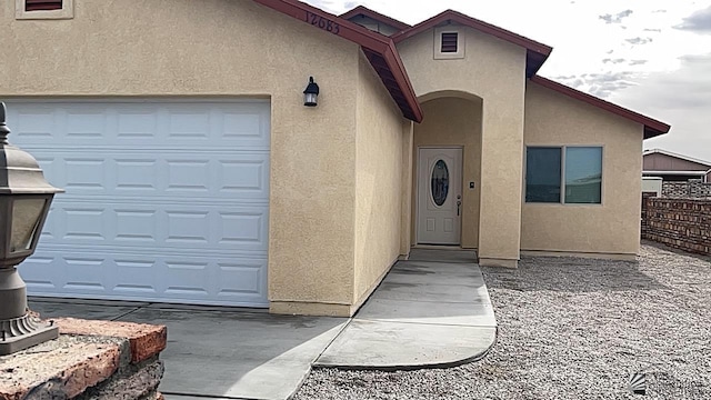 12683 E 45th St, Yuma, AZ 85367 - view of exterior entry with a garage, fence, and stucco siding