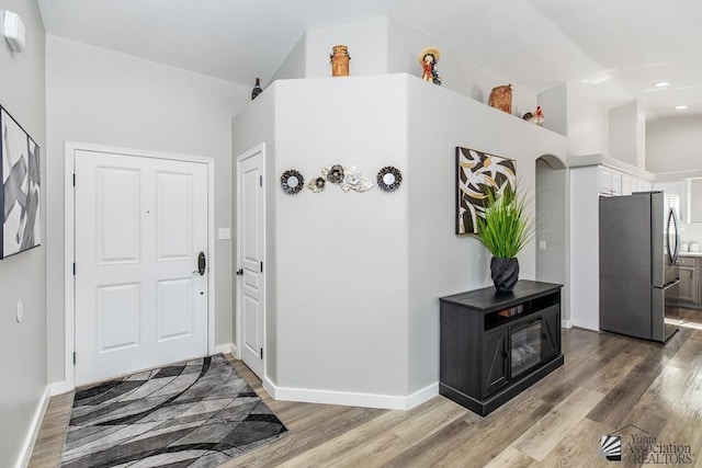 entrance foyer with baseboards, vaulted ceiling, recessed lighting, and wood finished floors