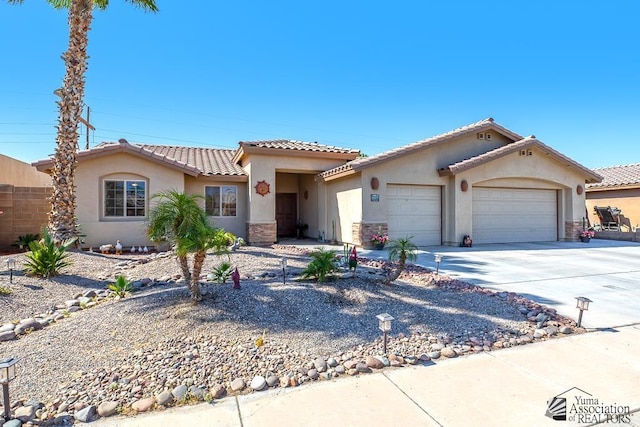 mediterranean / spanish home with stucco siding, an attached garage, driveway, and a tiled roof