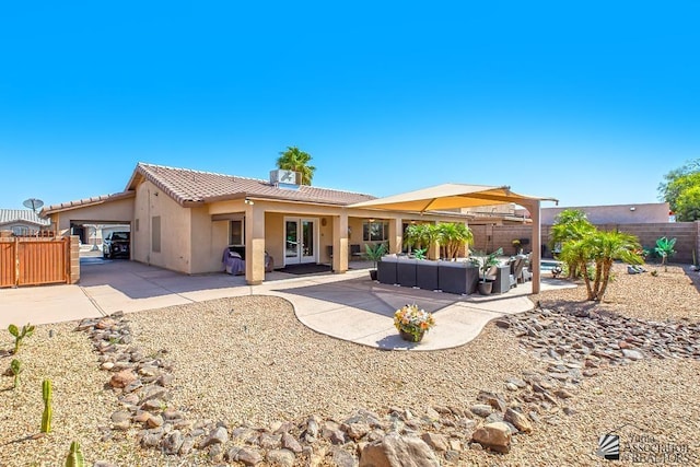 rear view of property featuring fence private yard, stucco siding, an outdoor hangout area, a tile roof, and a carport
