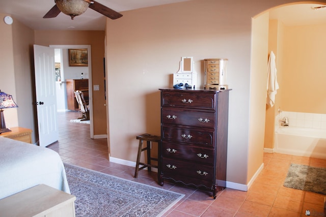 tiled bedroom featuring baseboards and arched walkways