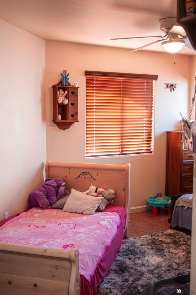 bedroom featuring baseboards, ceiling fan, and tile patterned floors