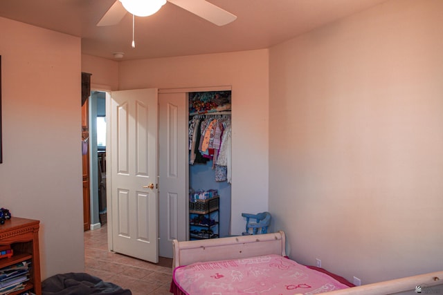 tiled bedroom featuring a ceiling fan and a closet