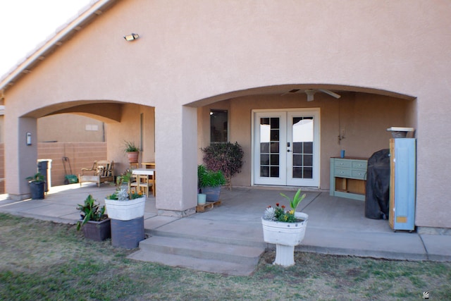 rear view of house featuring french doors, a ceiling fan, a patio, and stucco siding