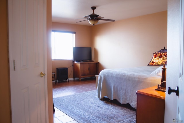 tiled bedroom featuring ceiling fan and baseboards