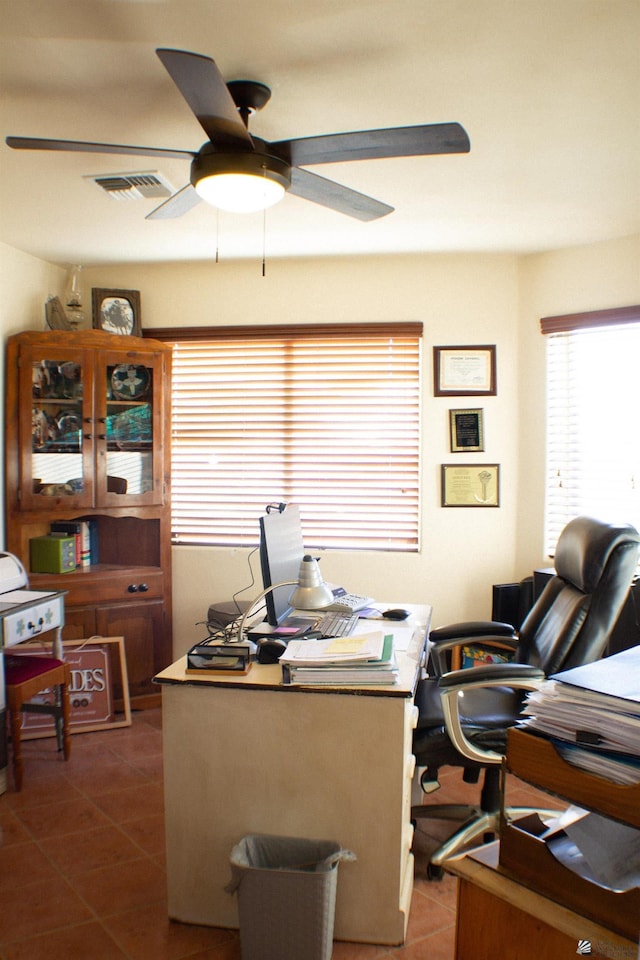 office space featuring visible vents, a ceiling fan, and dark tile patterned flooring