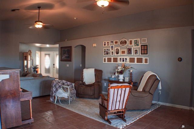living area with a ceiling fan, arched walkways, and lofted ceiling