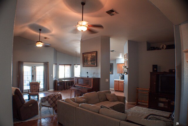 living area featuring visible vents, baseboards, ceiling fan, and vaulted ceiling