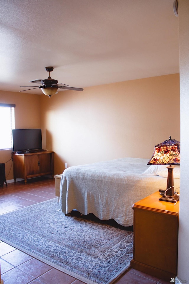 bedroom with baseboards, a ceiling fan, and tile patterned floors