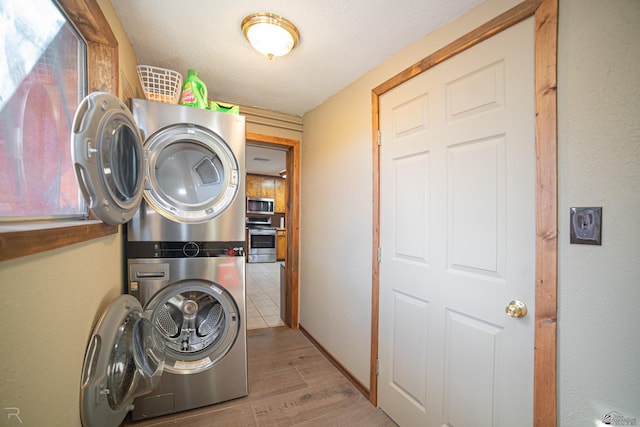 laundry room with estacked washer and dryer and wood finished floors