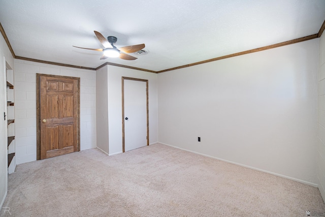 unfurnished bedroom with crown molding, carpet flooring, a ceiling fan, a closet, and baseboards