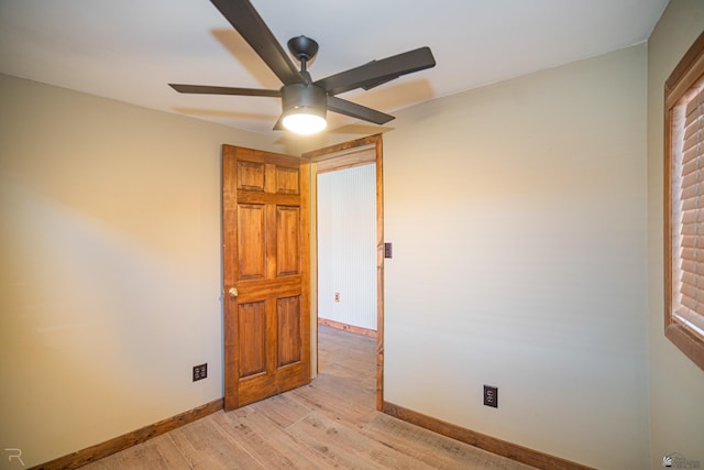 empty room with light wood finished floors, baseboards, and ceiling fan