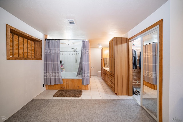 bathroom featuring tile patterned floors, vanity, shower / bathtub combination with curtain, and toilet