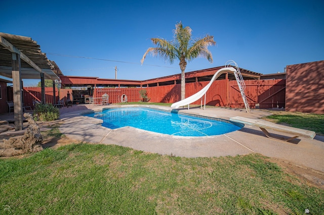 view of pool featuring a water slide, a diving board, and a patio area