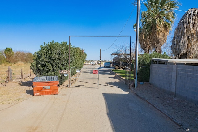 view of dirt / gravel road featuring a gate