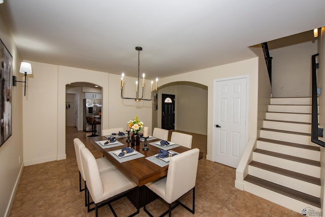 2172 S Terrace Way, Yuma, AZ 85364 - tiled dining space with arched walkways, a chandelier, stairway, and baseboards