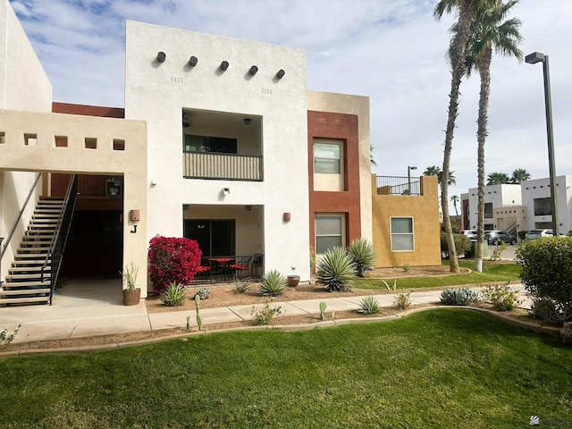 rear view of house featuring stairway and stucco siding