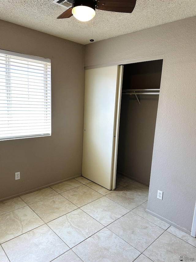 4732 W 17th Ln, Yuma, AZ 85364 - unfurnished bedroom with a closet, a textured ceiling, light tile patterned floors, and ceiling fan