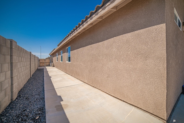 7850 E 44th Pl, Yuma, AZ 85365 - view of side of home with a patio, stucco siding, and fence
