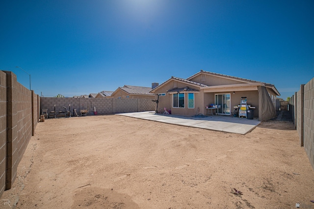 7850 E 44th Pl, Yuma, AZ 85365 - back of house with a fenced backyard, a patio, a tiled roof, and stucco siding
