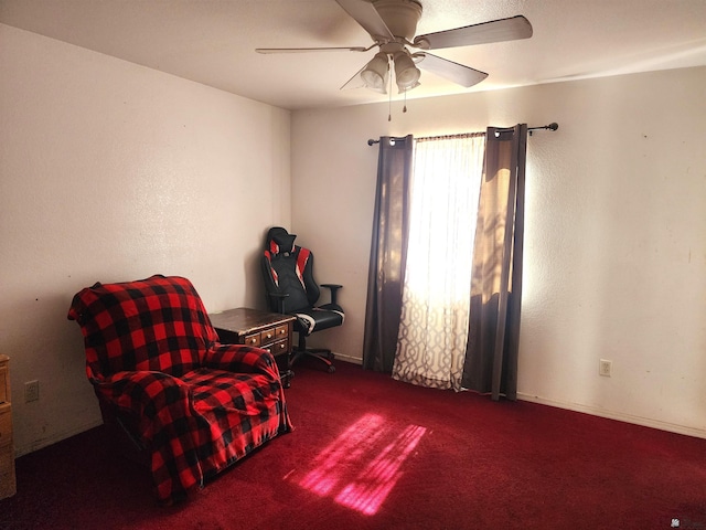 sitting room with a ceiling fan and carpet