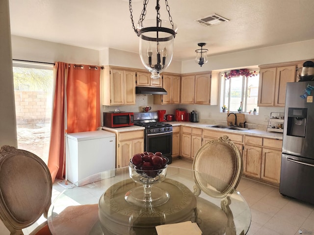 kitchen with under cabinet range hood, a sink, visible vents, appliances with stainless steel finishes, and light brown cabinetry