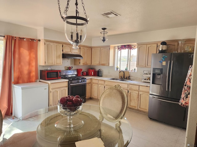 kitchen featuring visible vents, stainless steel appliances, under cabinet range hood, light brown cabinets, and a sink