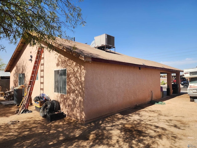 view of side of property with central AC and stucco siding