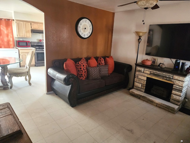 living room featuring ceiling fan and a fireplace