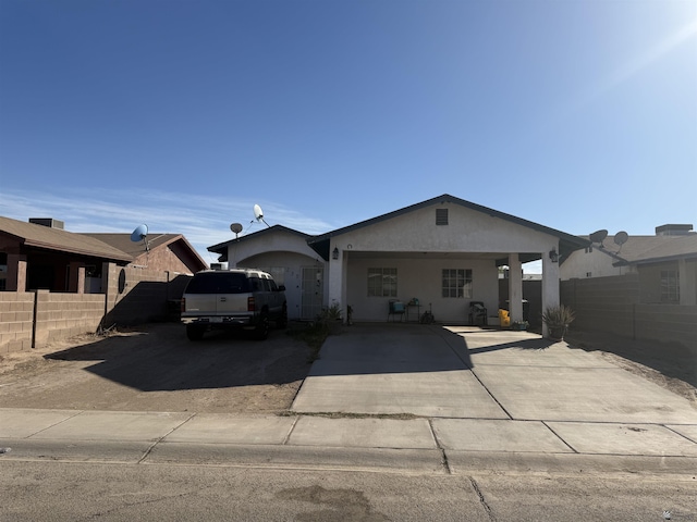 ranch-style house with fence, stucco siding, and concrete driveway