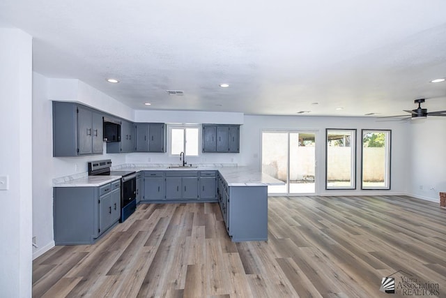 1934 S Athens Ave, Yuma, AZ 85364 - kitchen with stainless steel range with electric cooktop, a sink, a peninsula, healthy amount of natural light, and recessed lighting