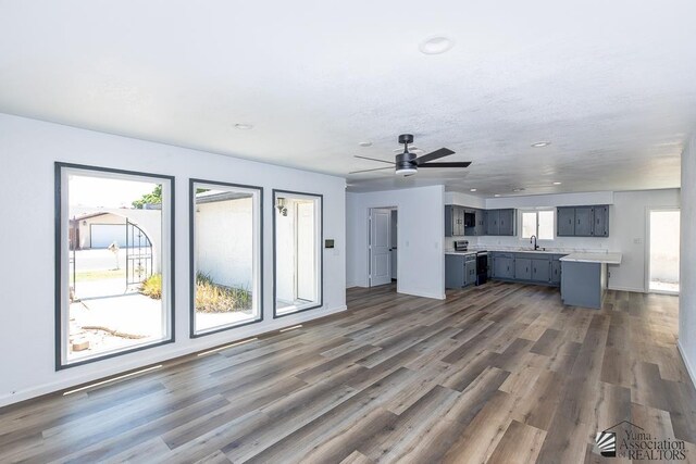 1934 S Athens Ave, Yuma, AZ 85364 - unfurnished living room with dark wood-style floors, a ceiling fan, a sink, recessed lighting, and baseboards