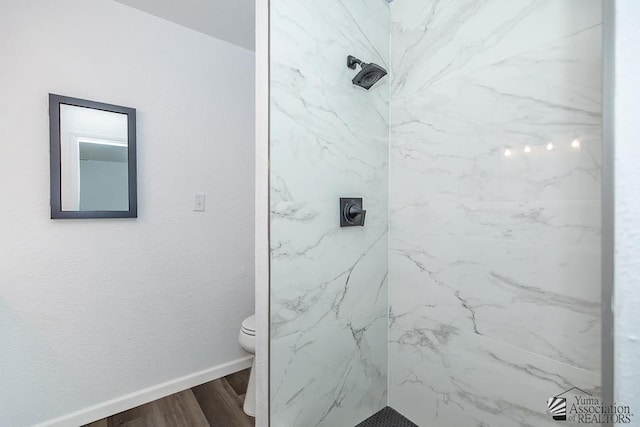 1934 S Athens Ave, Yuma, AZ 85364 - bathroom with a marble finish shower, toilet, wood finished floors, and baseboards