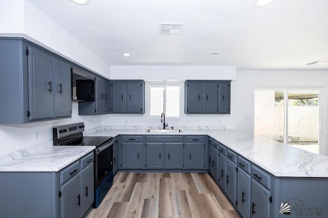 1934 S Athens Ave, Yuma, AZ 85364 - kitchen with range with electric stovetop, a sink, a peninsula, light wood-style flooring, and recessed lighting