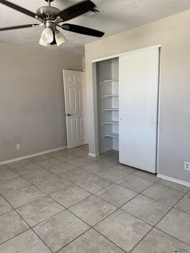 1435 S Thomas Ave, Yuma, AZ 85364 - unfurnished bedroom with a closet, light tile patterned floors, a textured ceiling, and a ceiling fan