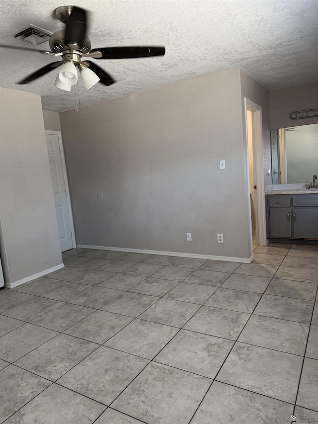 1435 S Thomas Ave, Yuma, AZ 85364 - unfurnished bedroom with a textured ceiling, a sink, light tile patterned floors, baseboards, and ceiling fan