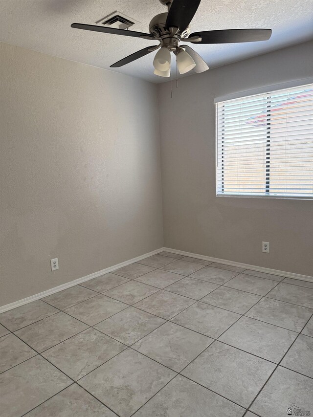 1435 S Thomas Ave, Yuma, AZ 85364 - unfurnished room with a textured ceiling, ceiling fan, light tile patterned floors, and baseboards