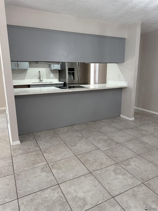 1435 S Thomas Ave, Yuma, AZ 85364 - kitchen with stainless steel fridge with ice dispenser, light countertops, a textured ceiling, a sink, and light tile patterned flooring