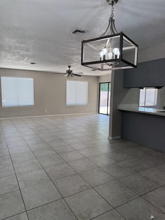 1435 S Thomas Ave, Yuma, AZ 85364 - unfurnished living room with tile patterned floors, a textured ceiling, a chandelier, and ceiling fan