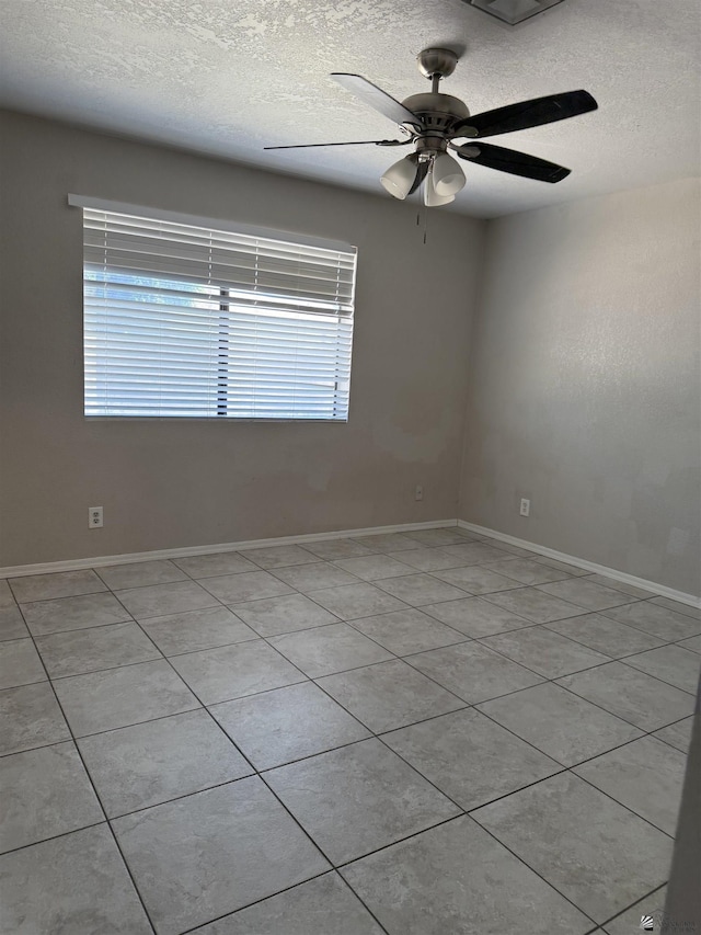 1435 S Thomas Ave, Yuma, AZ 85364 - empty room with a textured ceiling, ceiling fan, light tile patterned flooring, and baseboards