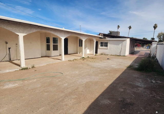 rear view of property with a patio and stucco siding