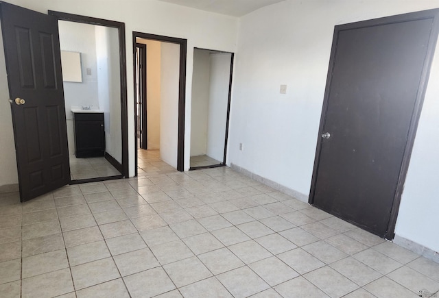 unfurnished bedroom with light tile patterned floors and baseboards
