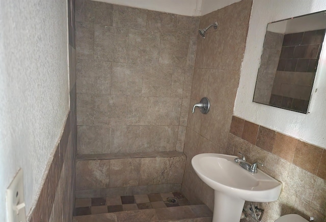 full bathroom with a sink and tiled shower