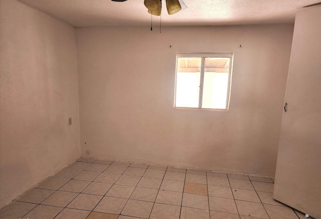unfurnished room with a textured ceiling, ceiling fan, and light tile patterned flooring