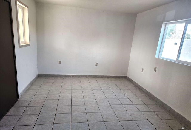 spare room featuring baseboards and light tile patterned floors