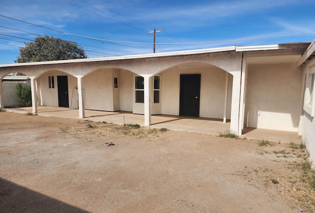 exterior space with a patio area and stucco siding