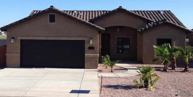 5332 E 33rd Pl, Yuma, AZ 85365 - mediterranean / spanish house with an attached garage, driveway, stucco siding, and a tiled roof