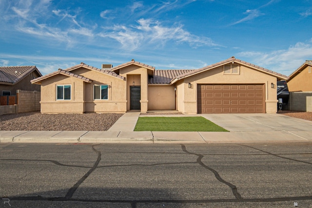 7654 E 41st St, Yuma, AZ 85365 - view of front of home with driveway, a tile roof, fence, an attached garage, and stucco siding
