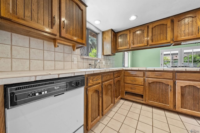 1228 S 40th Dr, Yuma, AZ 85364 - kitchen featuring white dishwasher, brown cabinets, light tile patterned flooring, a sink, and healthy amount of natural light